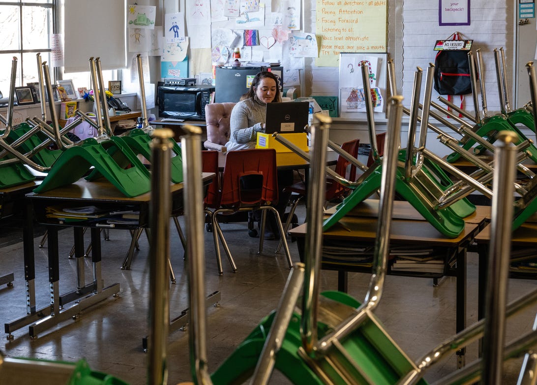 An elementary school teacher at a laptop in an empty classroom in Kentucky,