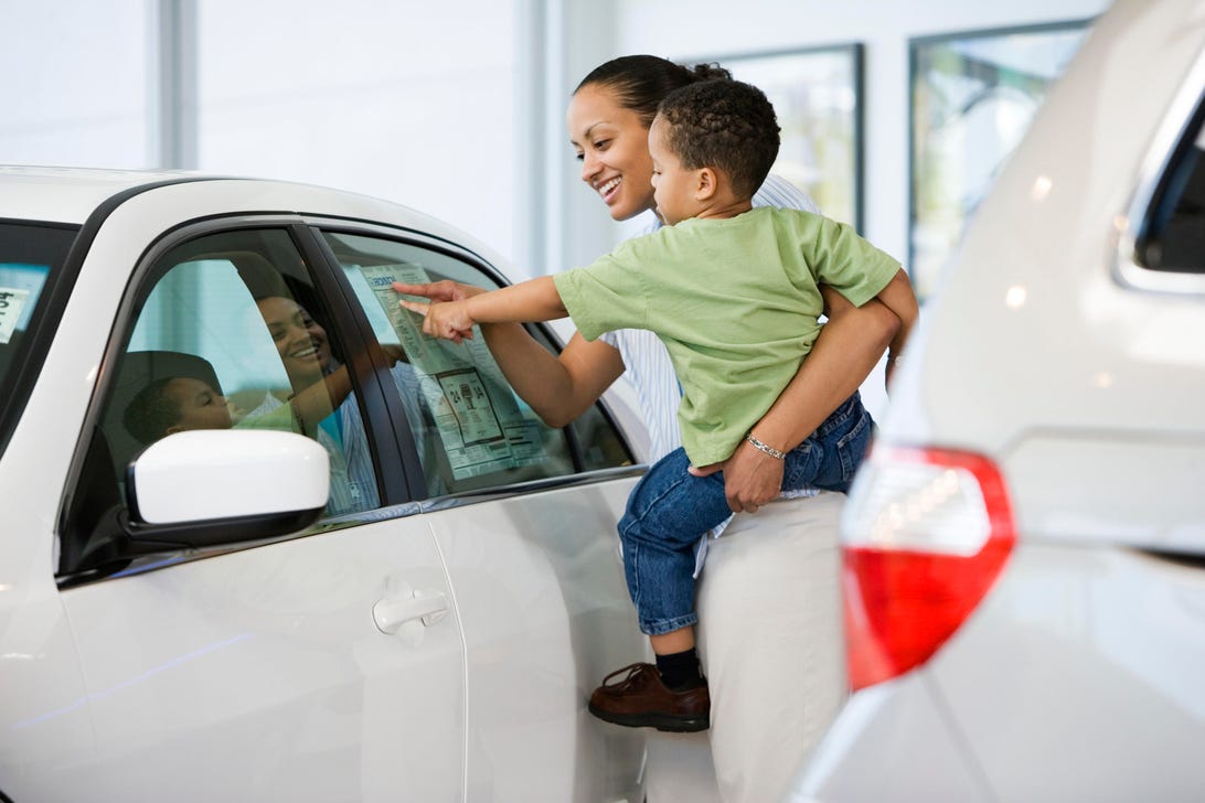 Woman and Son Looking at Car's Sticker Price