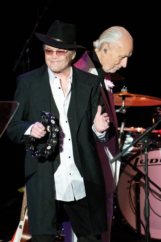 Mike Nesmith (detrás) y Micky Dolenz se presentan en el escenario del Teatro Griego de Los Ángeles el 14 de noviembre de 2021, durante el espectáculo final de The Monkees ' "Tour de despedida del 55 aniversario"