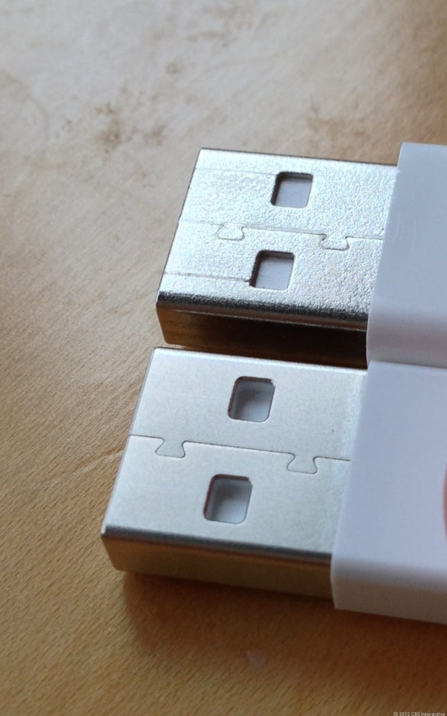 Apple's Lightning USB plug (bottom) and Apple's previous-generation 30-pin plug (top).