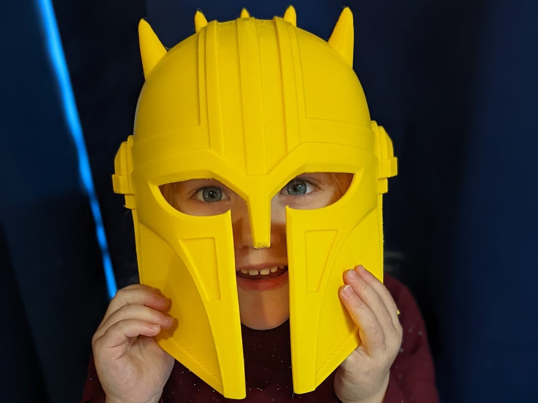 Small child wearing a helmet from the Mandalorian