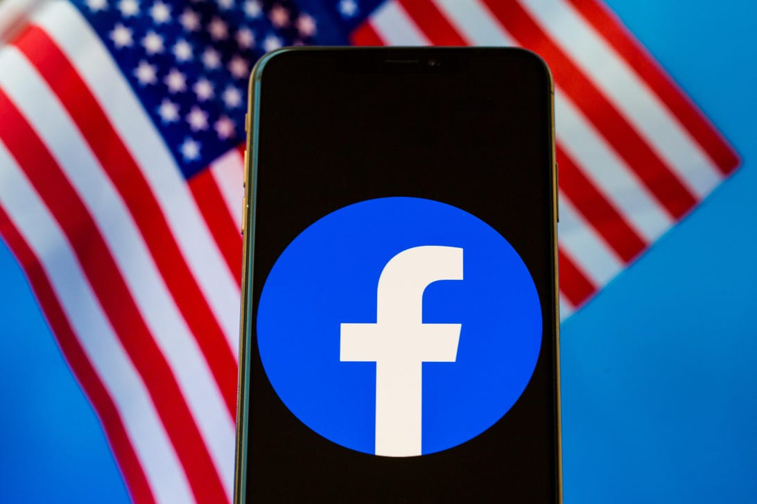 Facebook logo on a phone screen, with US flags in the background