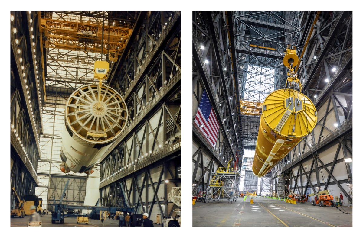 Two rocket stages, Saturn V on the left and SLS on the right, dangle at similar angles inside a cavernous rocket garage.