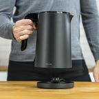 person holding black electric kettle 