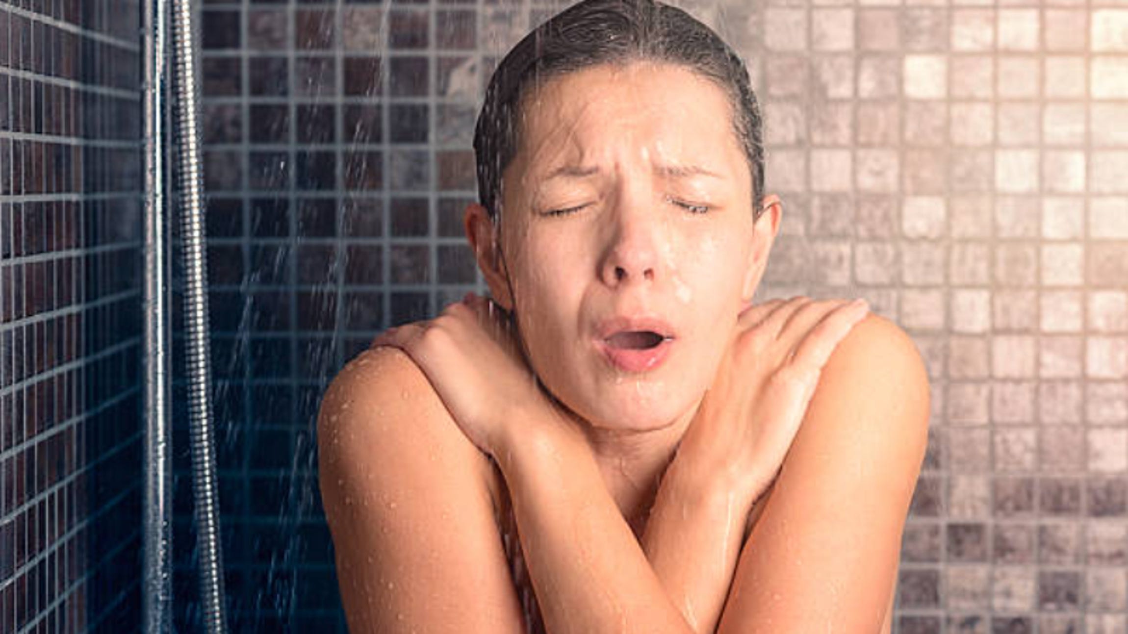 woman having a cold shower and struggling