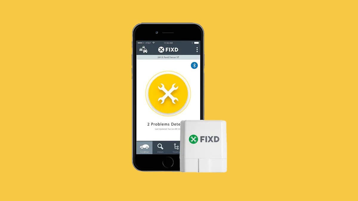 A Fixd OBD2 scanner rests near a phone displaying diagnostics using the app.