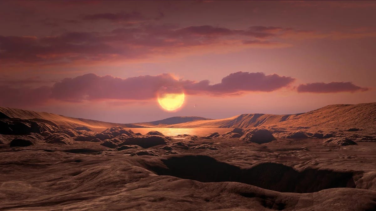 Illustration from POV of standing on a rocky exoplanet like Wolf 1069 b while looking toward its star. Mountainous landscape with clouds in colors of red and brown.