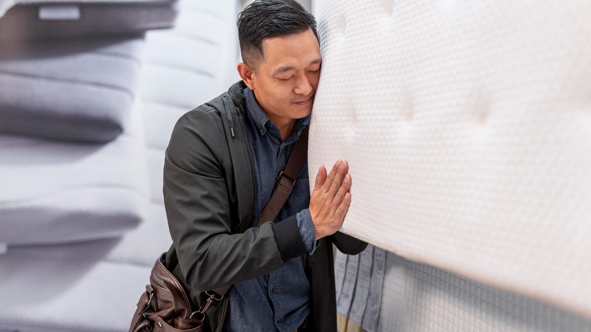 Man choosing a mattress size while shopping.