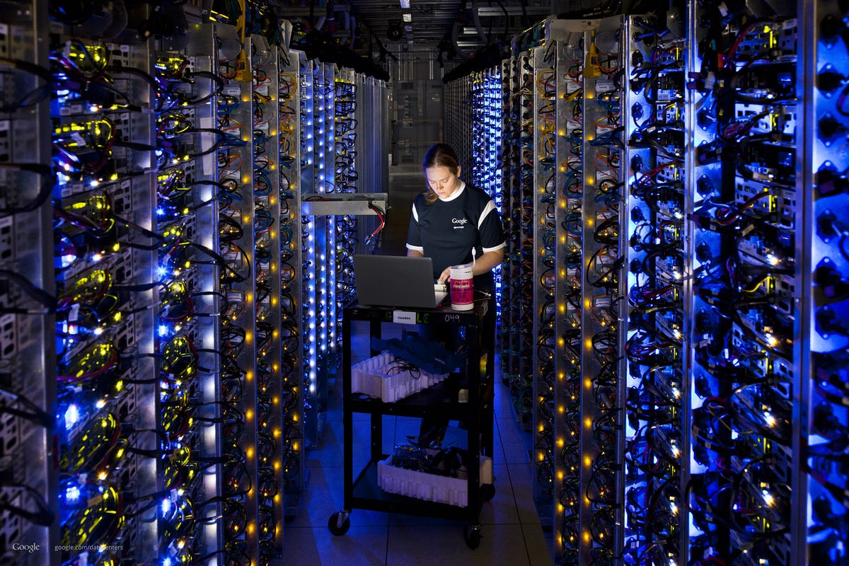 Denise Harwood diagnoses an overheating CPU inside a long aisle between racks of computing gear in a Google data center.