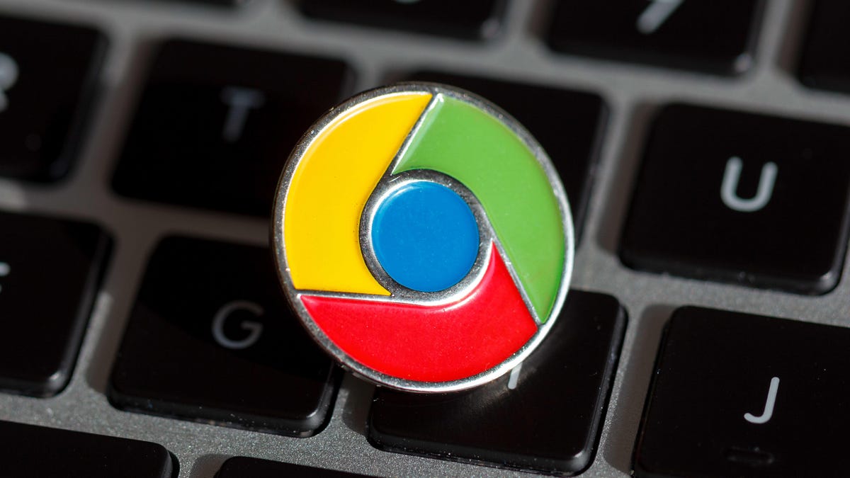 A Google Chrome lapel pin on a MacBook keyboard