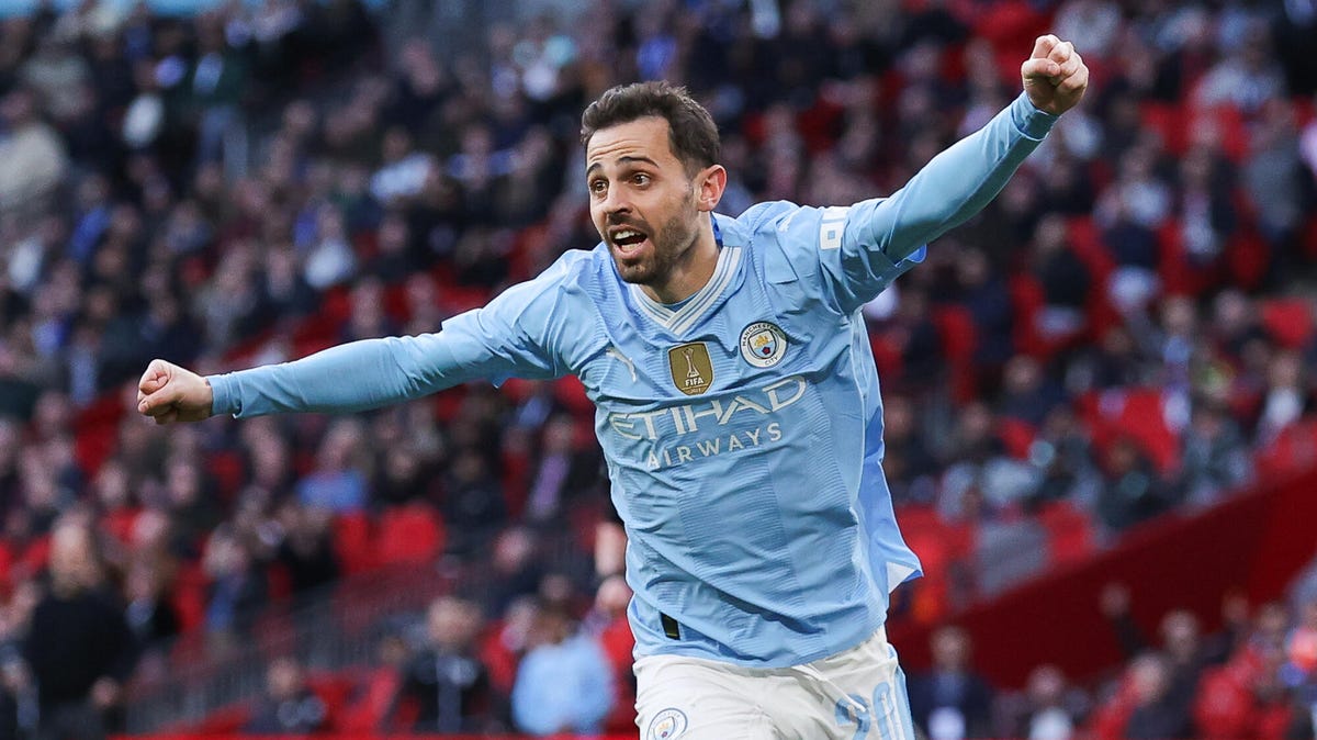 Bernardo Silva of Manchester City celebrating - arms outstretched, fists clenched.