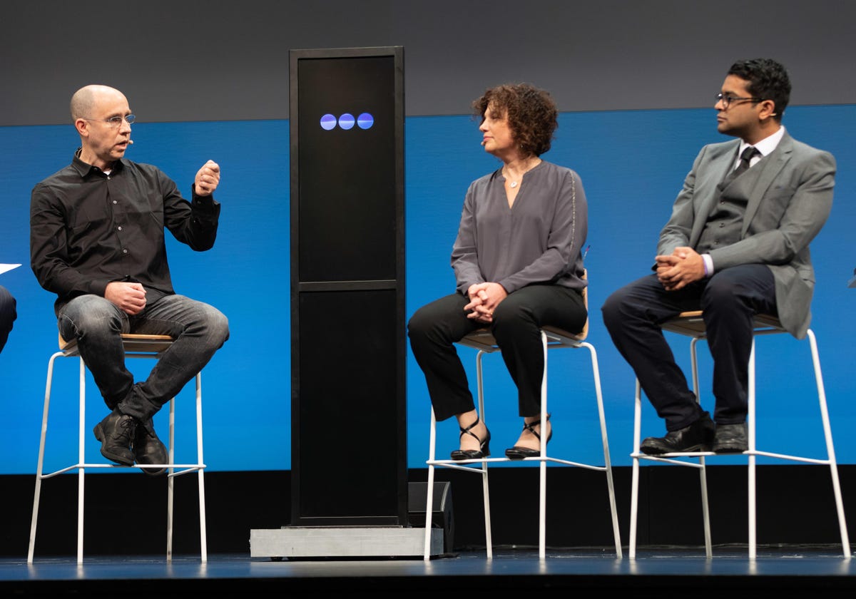 Humans discussed IBM's AI debate technology at a contest touting the tech. From left to right: Noam Slonim, Project Debater's principal investigator at IBM Research; IBM's Project Debater screen; Ranit Aharonov, IBM's manager of Project Debater; and Harish Natarajan, the grand finalist at the 2016 World Debating Championships.
