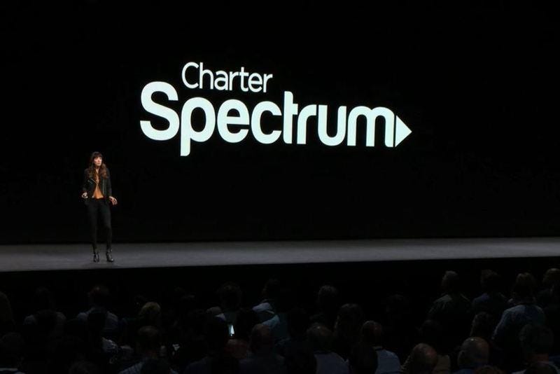 A woman stands on the WWDC stage with the Charter Spectrum logo behind her