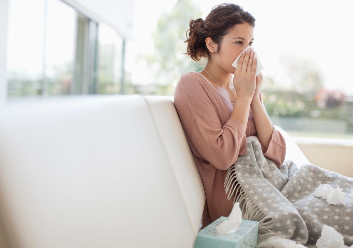 Woman with seasonal allergies blowing her nose