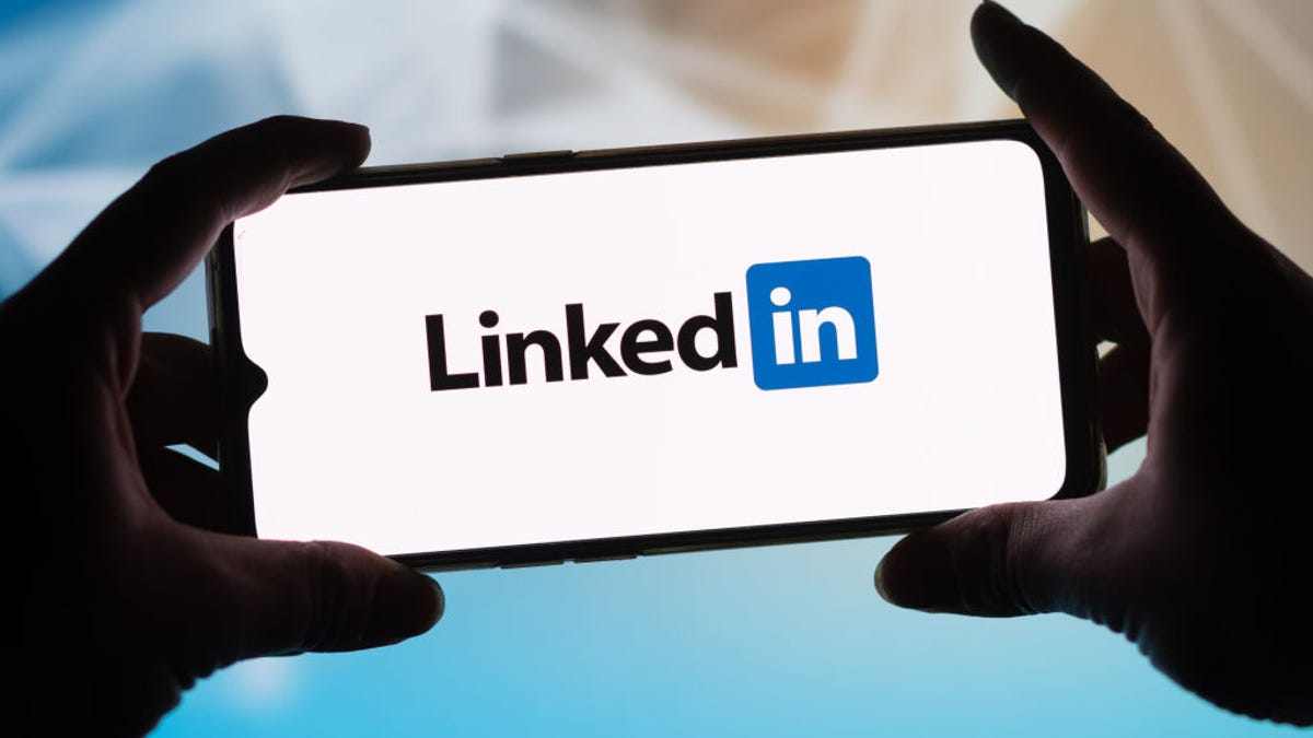 Person holding up smartphone with LinkedIn logo
