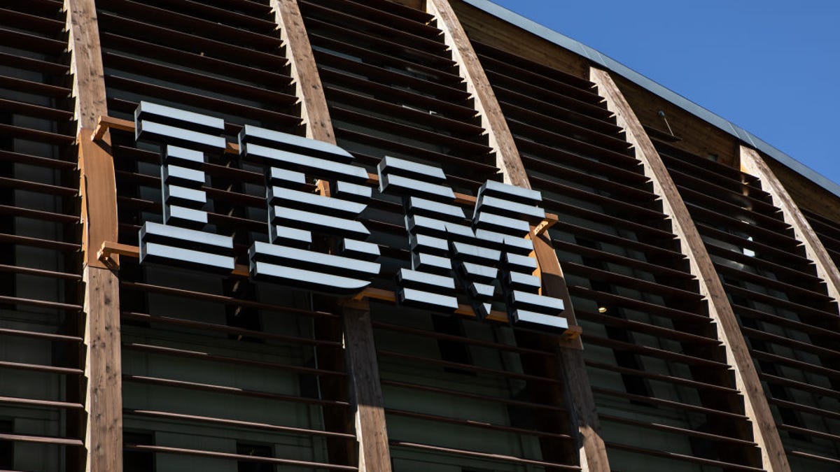 IBM's white logo is seen on the side of a building against a blue sky