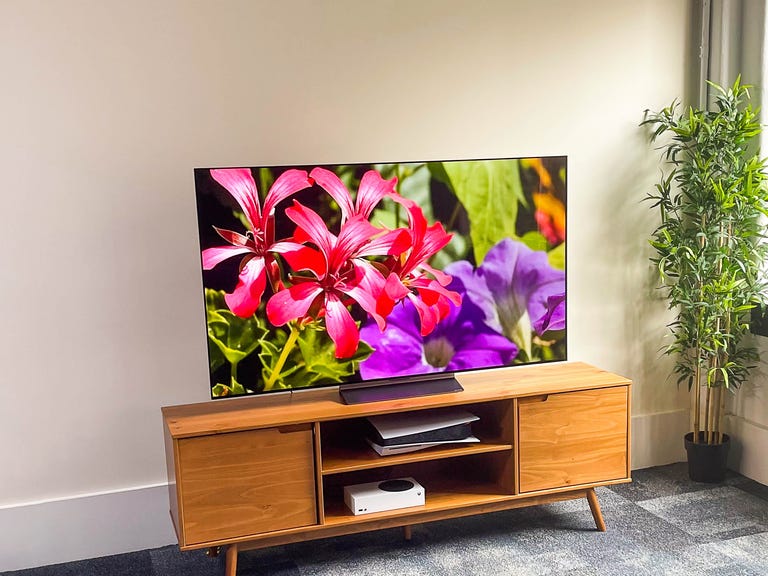 LG C2 OLED TV in a bright room on a wooden TV stand