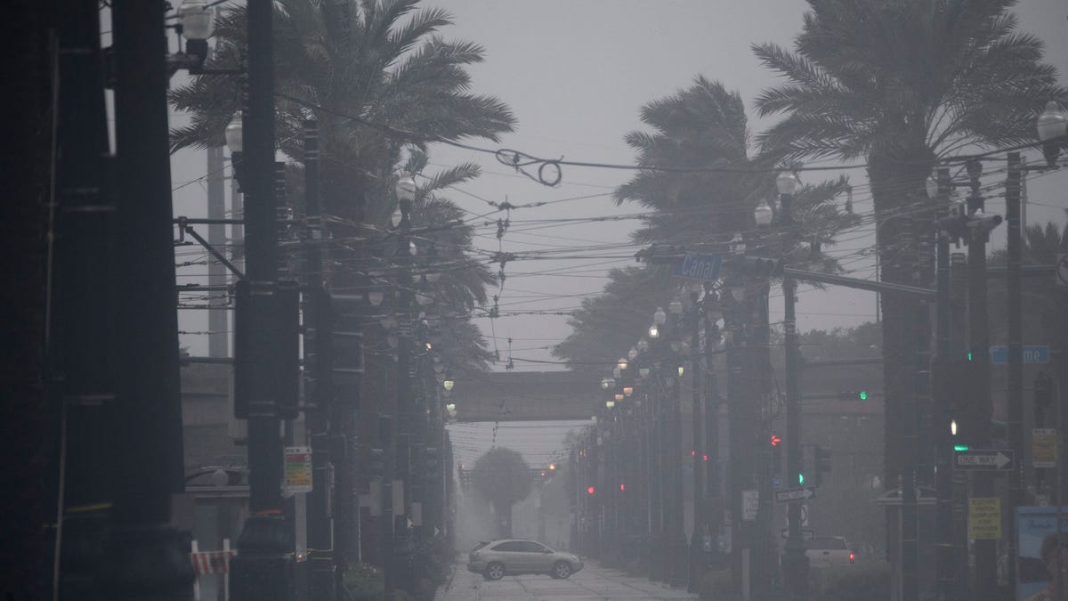 A car drives through rain and high winds across Canal Street in New Orleans during Hurricane Ida.