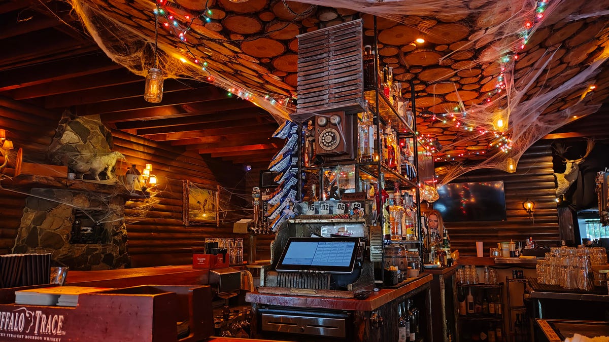 A bar interior, decorated like a lodge (and webbed up a bit for spooky season).