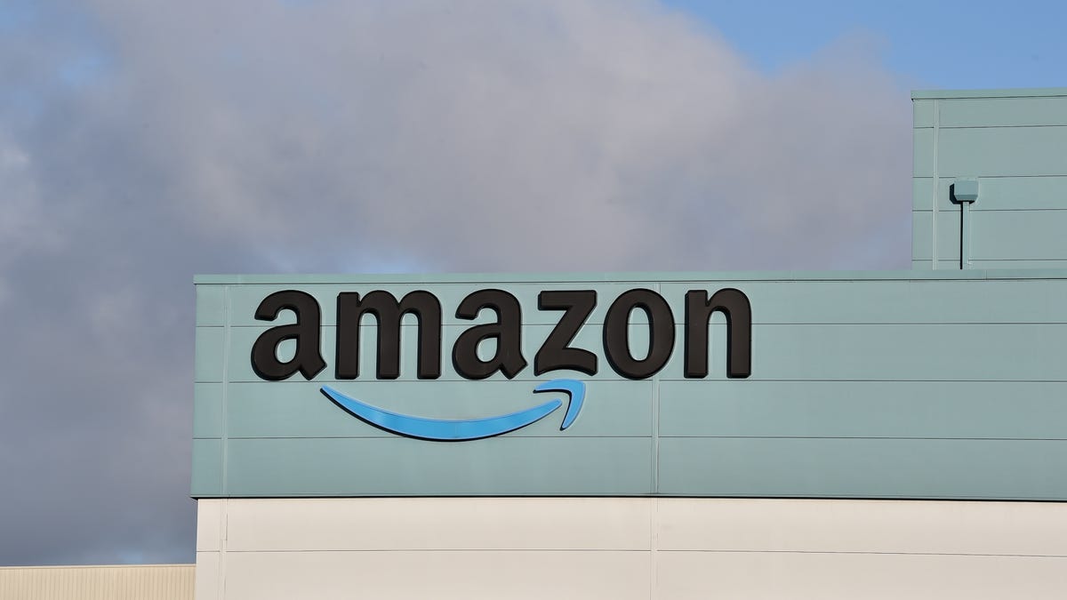 Amazon logo sits on top of warehouse building