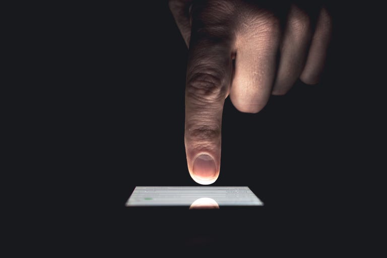 Cropped Image Of Hand Touching Mobile Screen Over Black Background