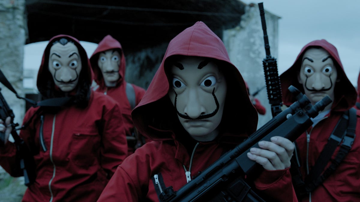 Money Heist bank robbers disguise themselves in red overalls and masks by the painter Dalí.