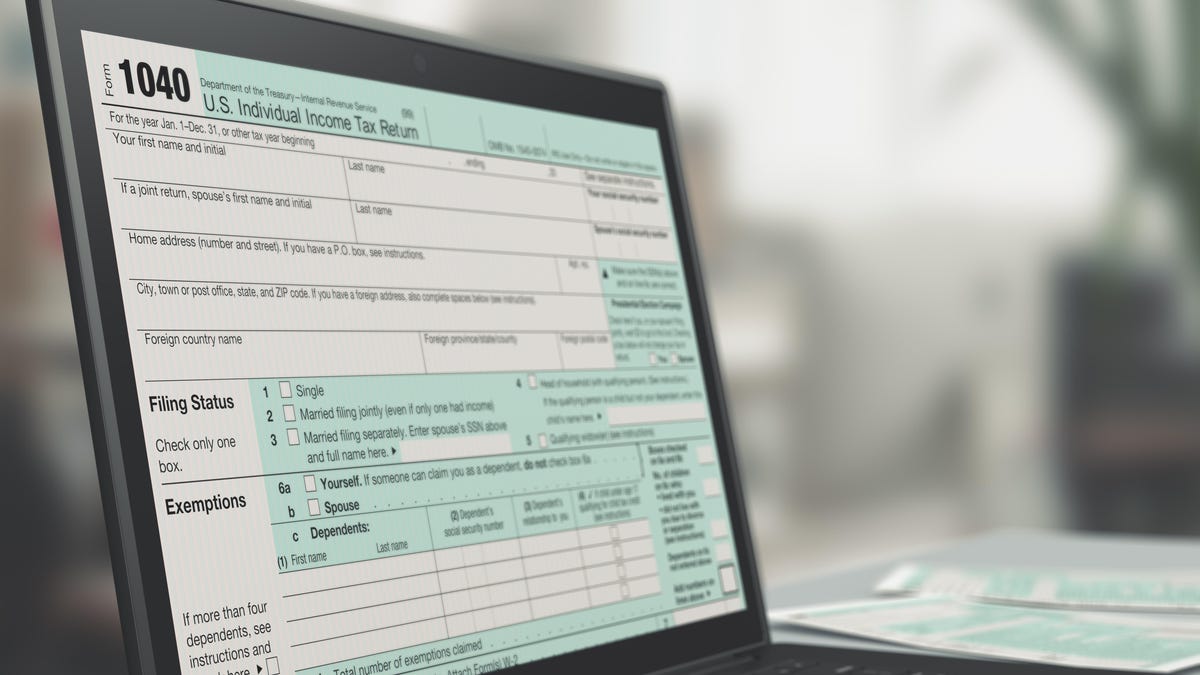 a black laptop computer showing an IRS Form 1040 tax form on its screen