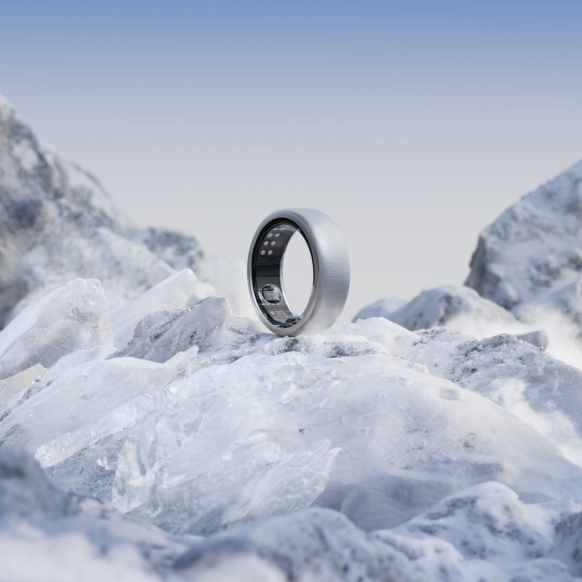 Oura's ring in a brushed titanium color against a glacier background