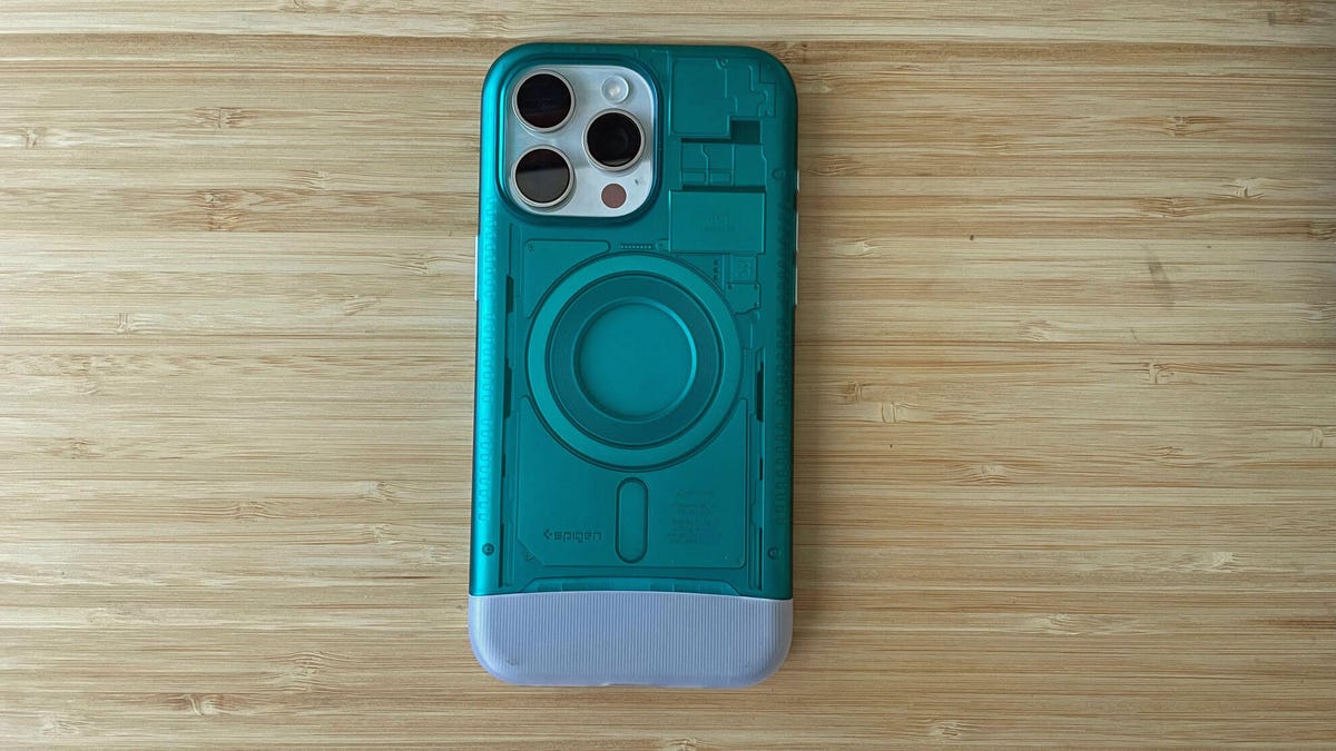 A white iPhone wrapped in a blue-green case on a wooden table.