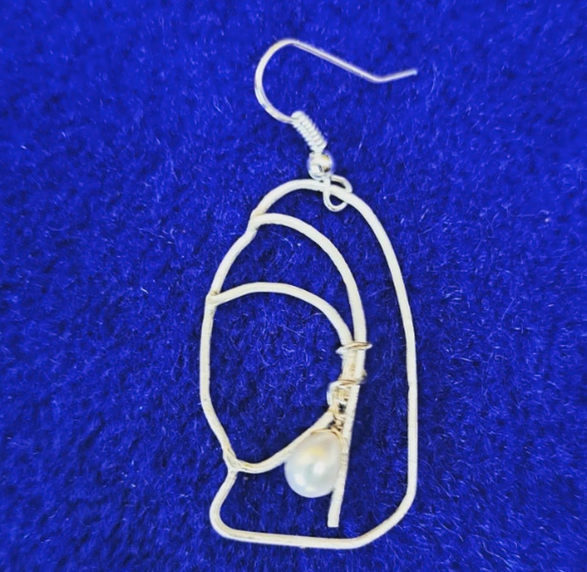 An earring in the shape of the painting Girl with a Pearl Earring