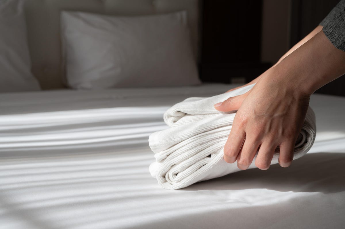 Hands arranging sheets on a bed
