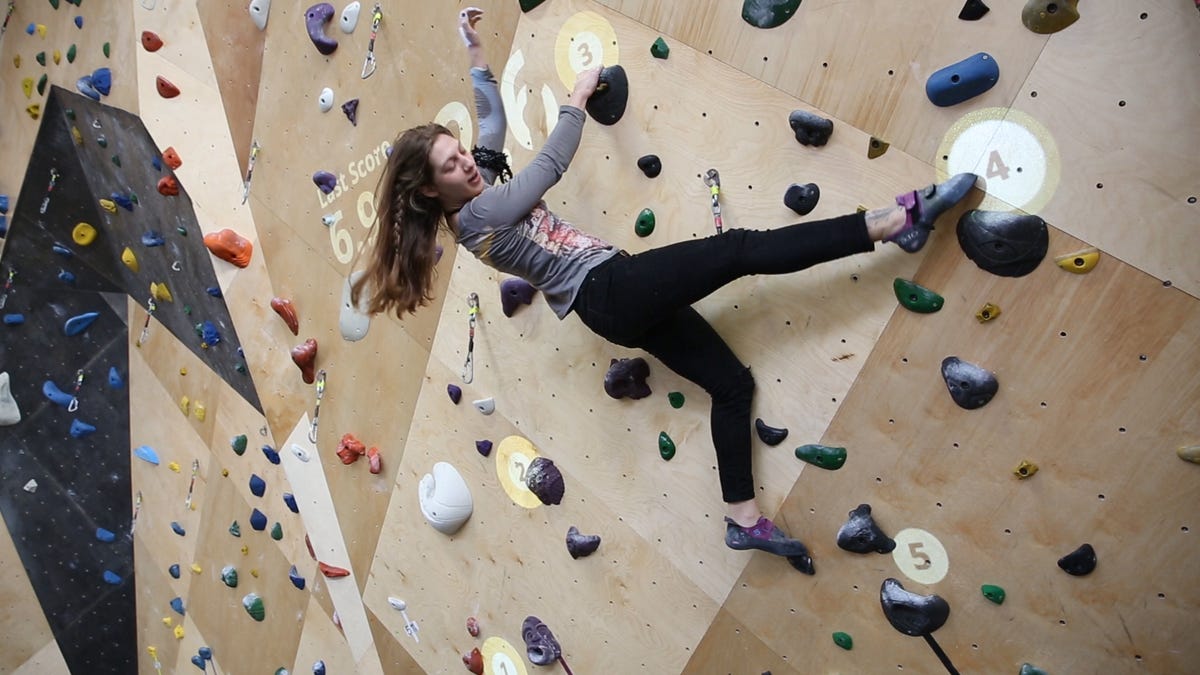 Woman scaling a wall in a rock climbing gym.