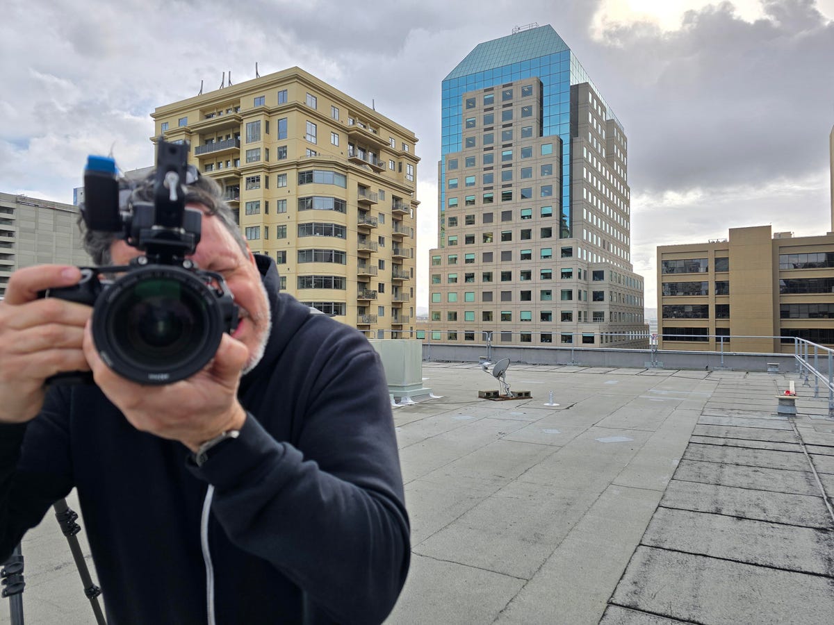 A rooftop with a man taking a photo of me