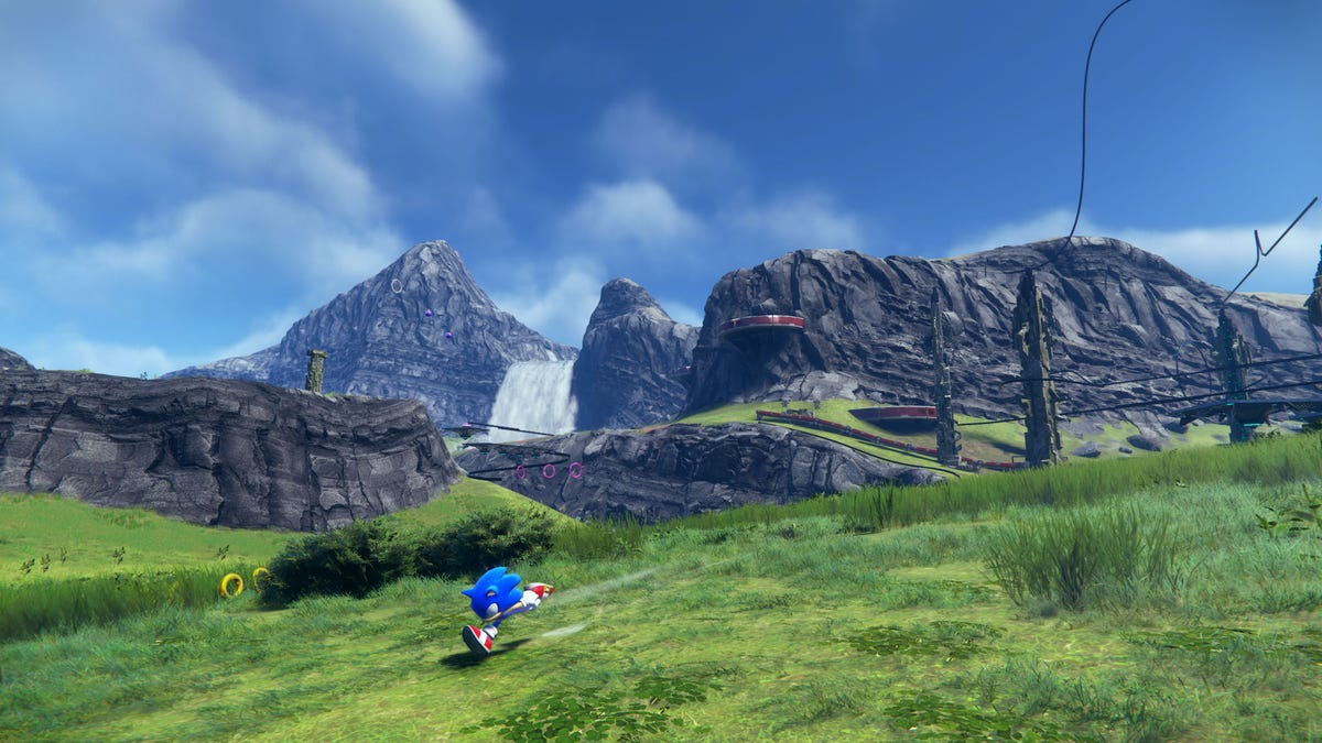 Sonic runs through a green field with mountains in the distance in Sonic Frontiers