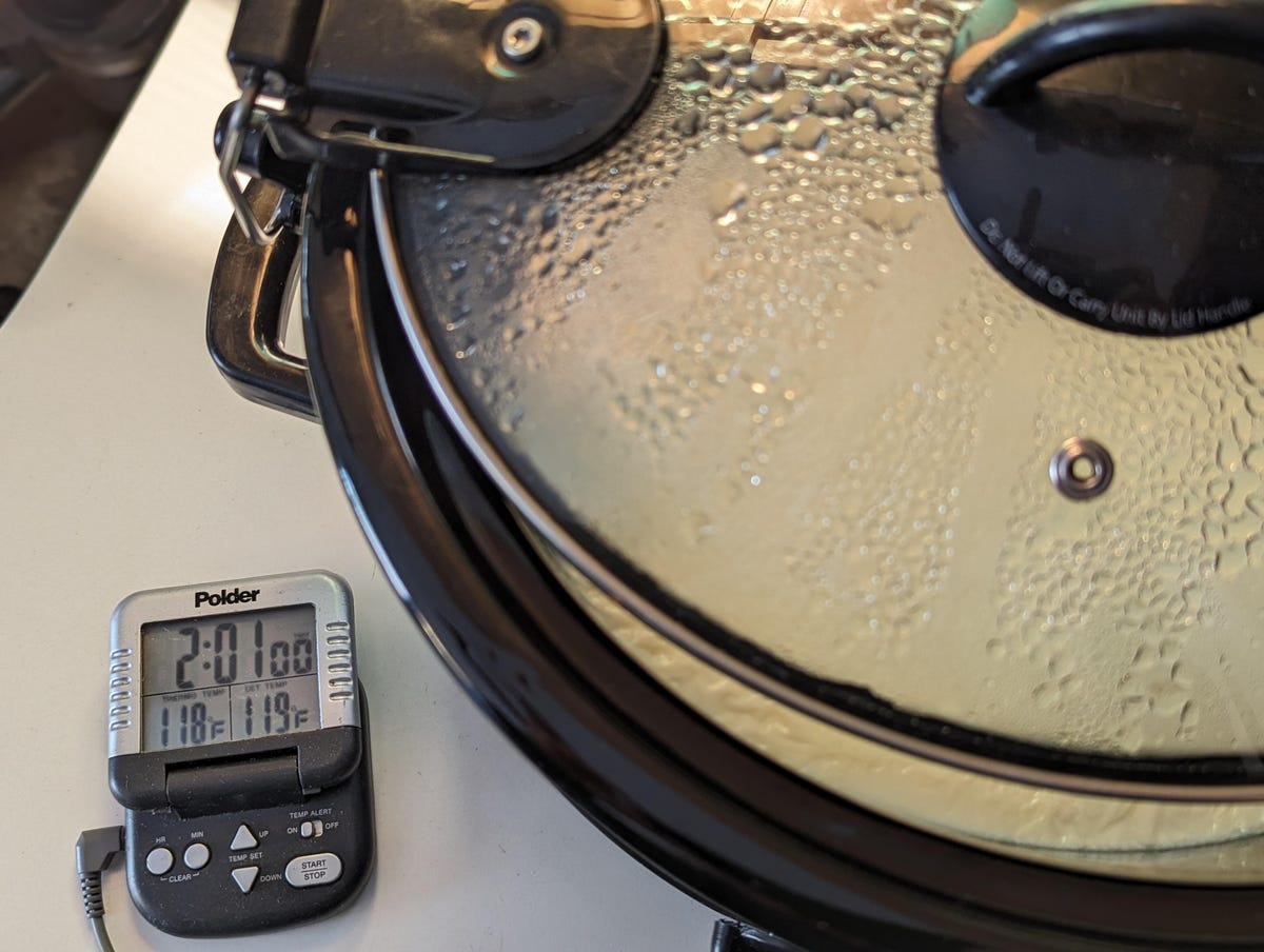 yogurt in slow cooker next to thermometer showing 118