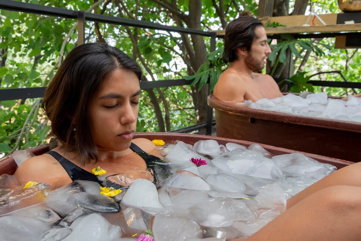 A man and a woman are taking ice baths on the outdoor terrace
