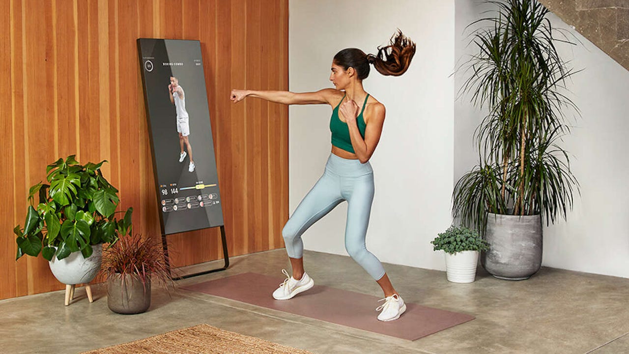 woman working out in front of a mirror device