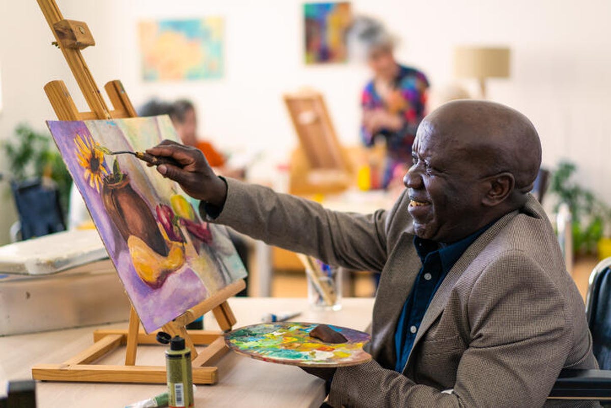 Older man painting a still life