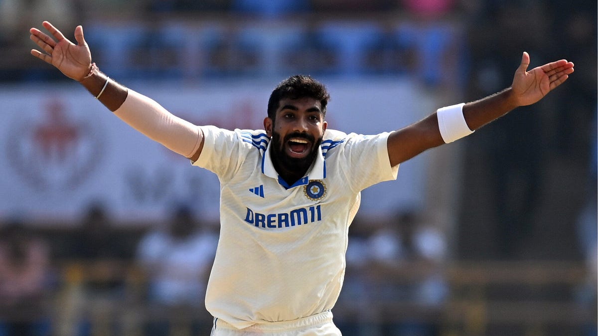 India bowler Jasprit Bumrah shouting, with both arms outstretched.