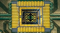Intel's Tunnel Falls quantum processor, a few millimeters across, nestled inside a circuit board with tiny wires leading to its electrical contacts