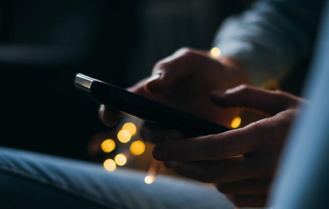 Cropped Image Of Person Using Phone At Night