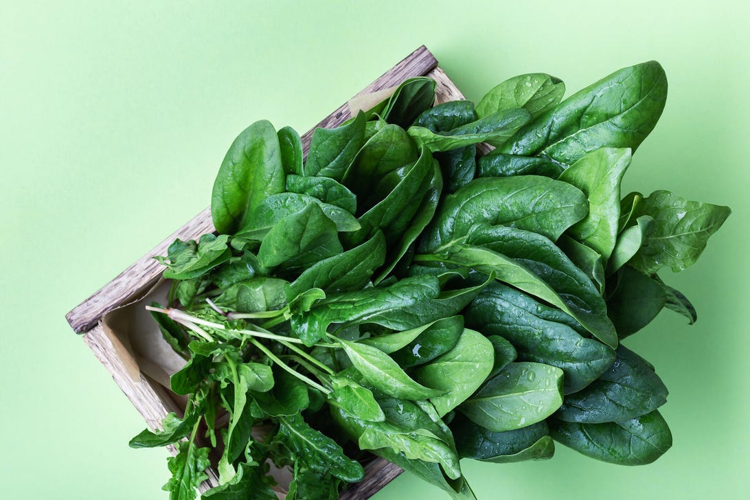spinach in a wooden crate on a green background