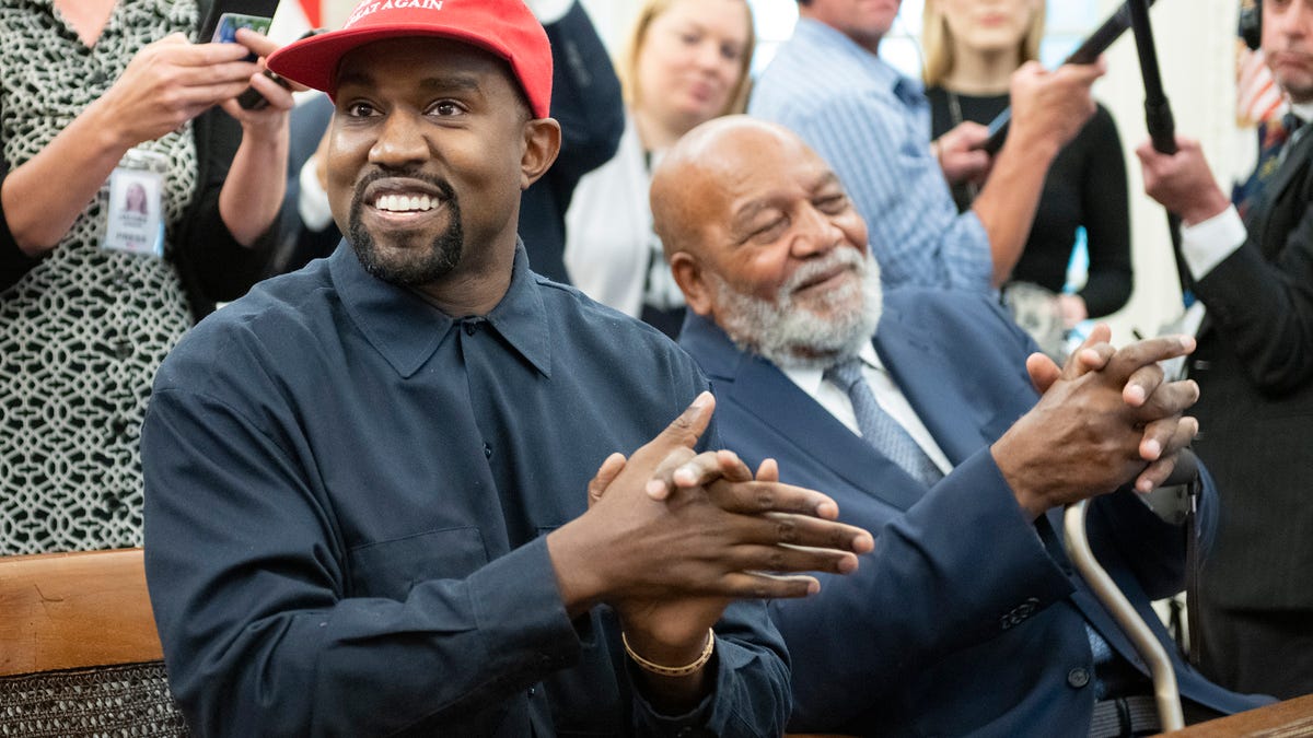 Kanye West, aka Ye, gazes intently at the camera while wearing sunglasses.