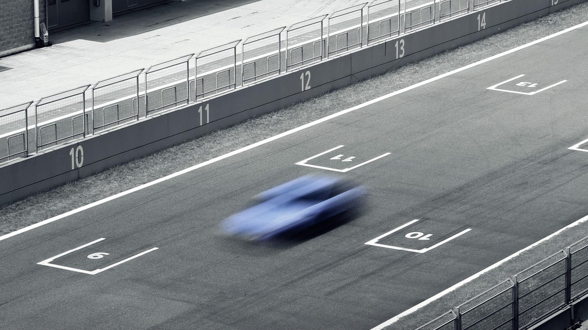 Race track grid with motion blurred N Blue vehicle passing through