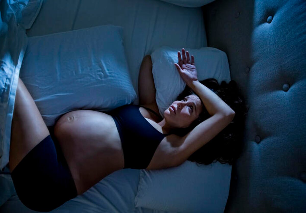 Pregnant woman with insomnia in bed