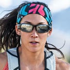 A woman running while wearing a pair of Bose Frames Tempo