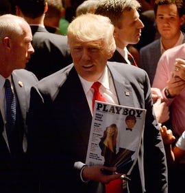 Trump shows a police officer his photo on the cover of Playboy magazine during a campaign event in July in Raleigh, North Carolina.