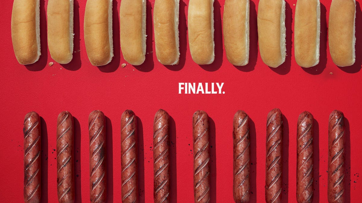 A row of hot dog buns over a row of grilled hot dogs, with the word "finally" in between