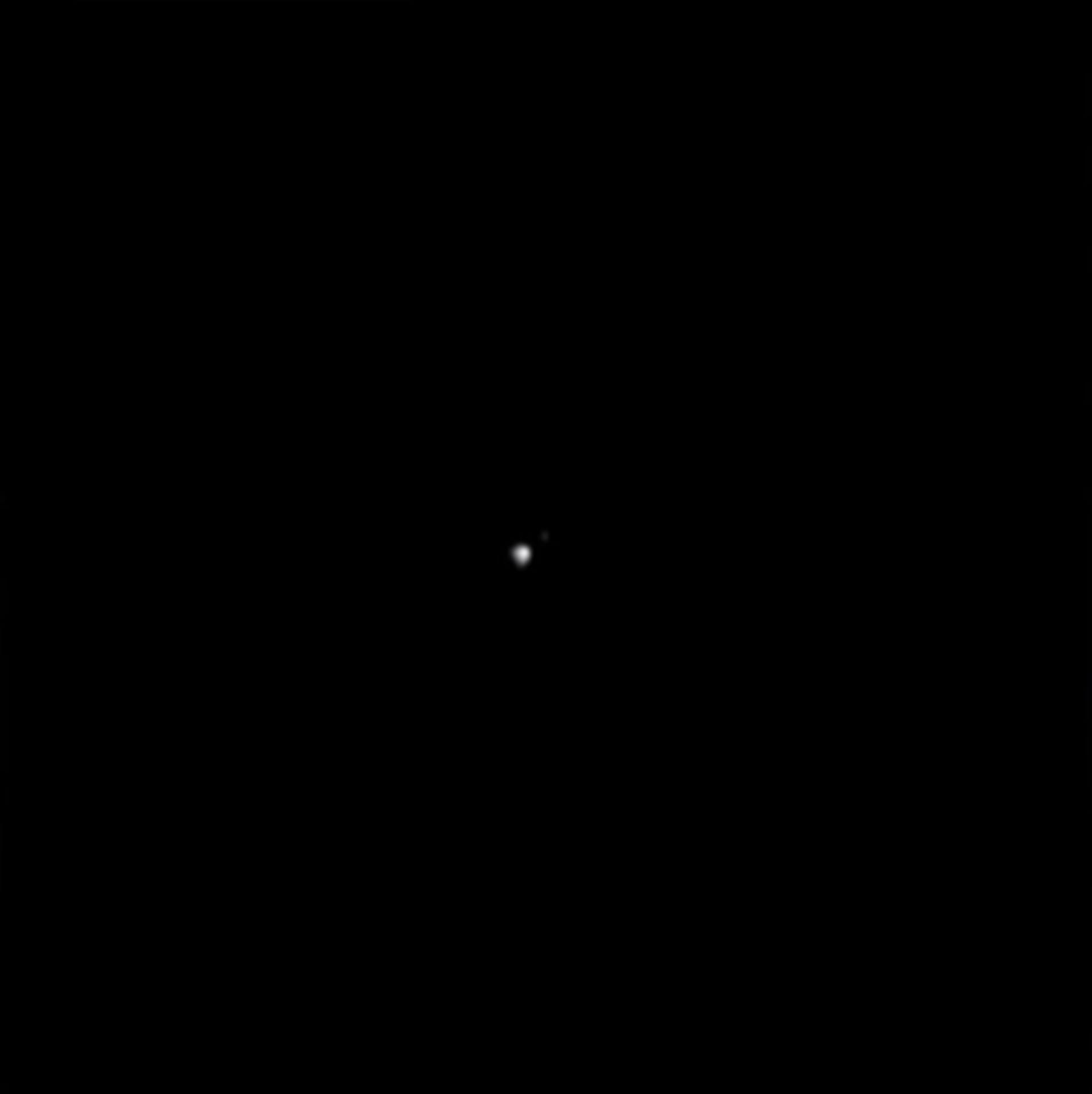 a pinprick of white light, the asteroid didymos, against the black of space. image taken by NASA's DART spacecraft