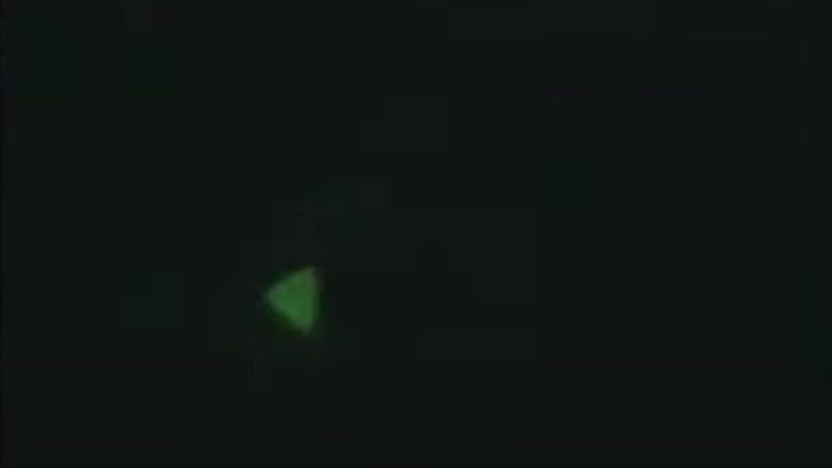 Green triangle against black backdrop, representing an unidentified aerial phenomenon.